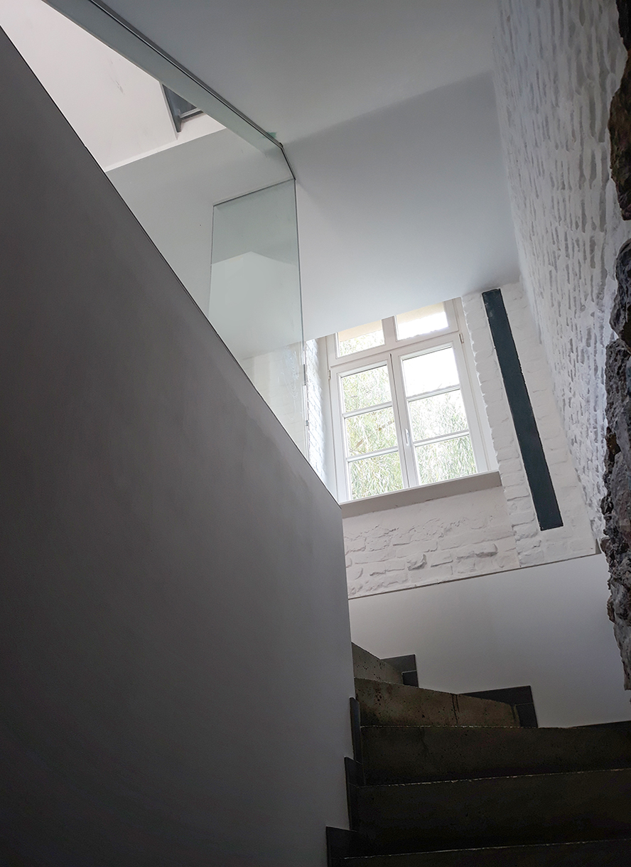 Bruchsteinwand freigelegt. Treppe Sichtbeton.