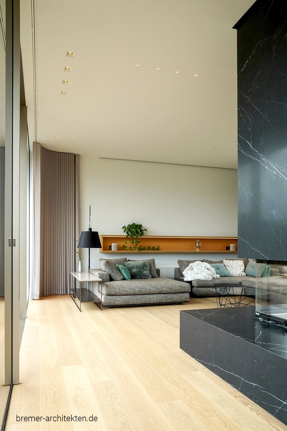 Dreiseitiger Kamin mit Natursteinverkleidung.